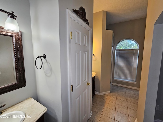 bathroom featuring tile patterned floors, a textured ceiling, and vanity