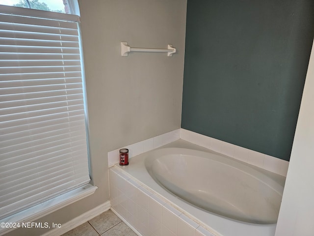 bathroom with a relaxing tiled tub and tile patterned floors