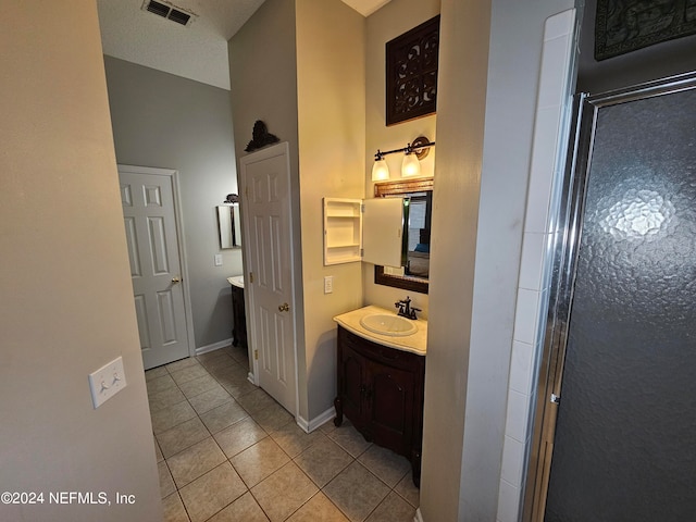 bathroom featuring tile patterned floors, an enclosed shower, and vanity