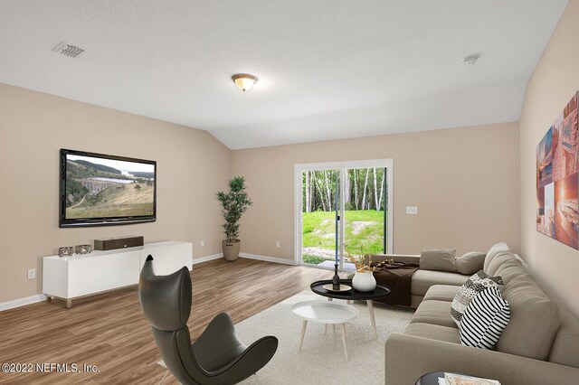 living room with hardwood / wood-style floors and lofted ceiling