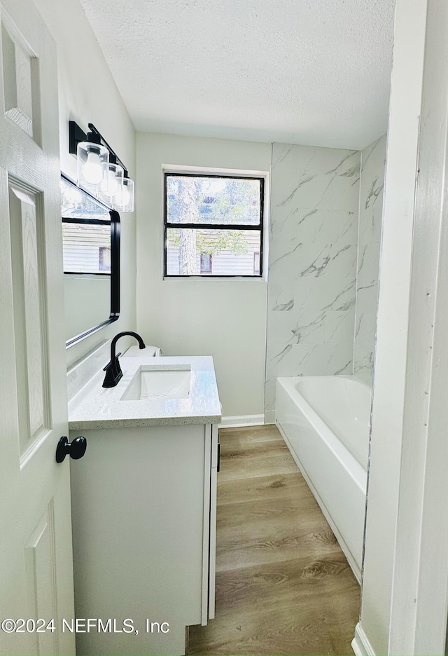 bathroom with vanity, hardwood / wood-style flooring, and a textured ceiling