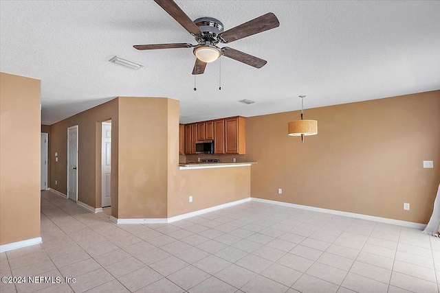 unfurnished living room featuring baseboards, visible vents, ceiling fan, a textured ceiling, and light tile patterned flooring