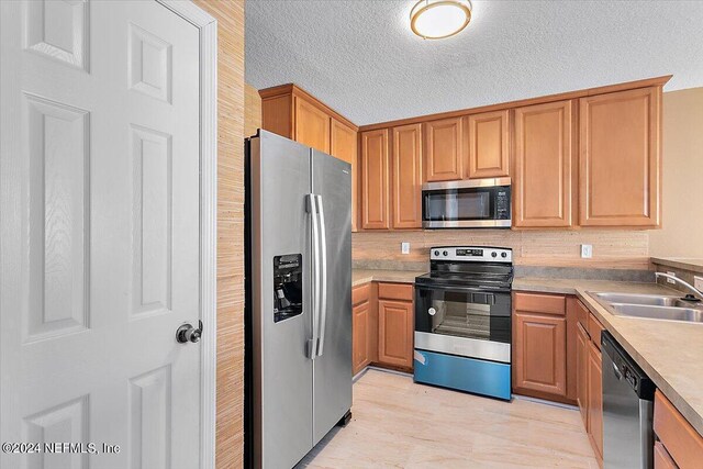 kitchen featuring sink, a textured ceiling, and appliances with stainless steel finishes