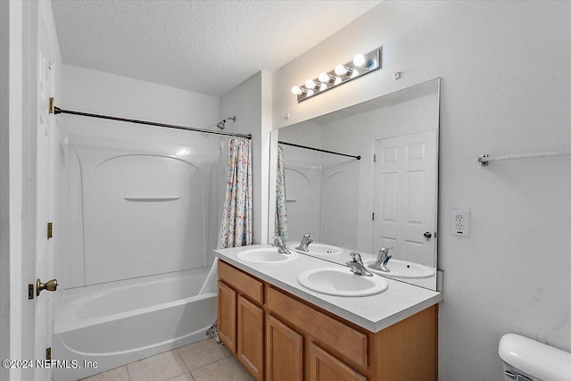 full bath featuring a textured ceiling, tile patterned flooring, and a sink