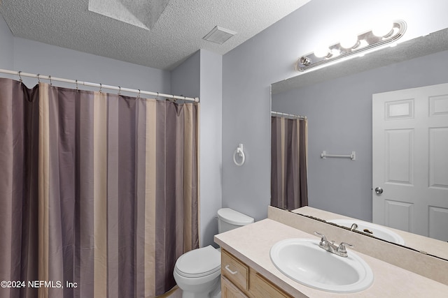 bathroom with vanity, toilet, and a textured ceiling