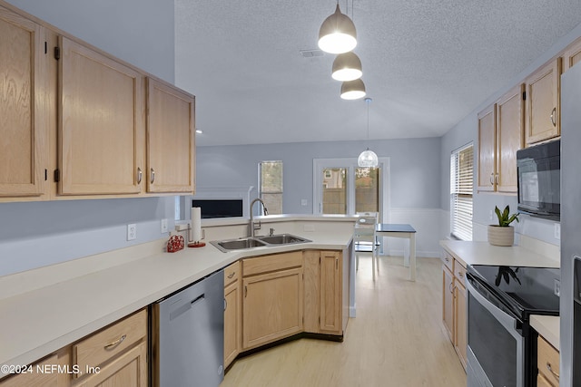 kitchen with light brown cabinets, stainless steel appliances, pendant lighting, and sink