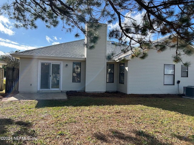 back of property featuring cooling unit, a patio area, and a lawn