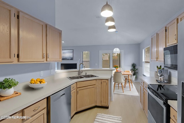 kitchen featuring pendant lighting, appliances with stainless steel finishes, light countertops, and light brown cabinetry