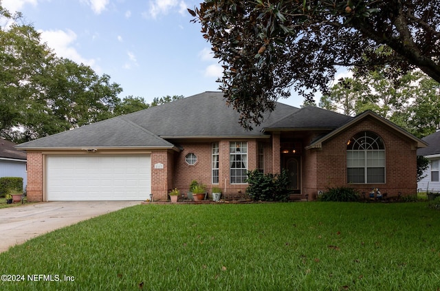 ranch-style house with a garage, brick siding, concrete driveway, and a front yard