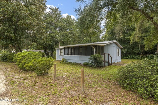 manufactured / mobile home featuring a front yard and a sunroom