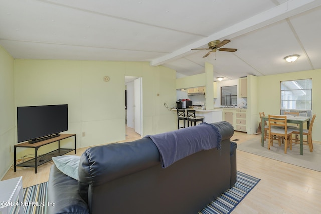 living room featuring ceiling fan, lofted ceiling with beams, and light hardwood / wood-style flooring