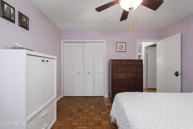 bedroom with a textured ceiling, ceiling fan, and dark parquet floors