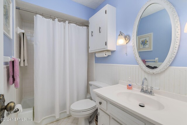 full bathroom with shower / bathtub combination with curtain, vanity, toilet, and a textured ceiling