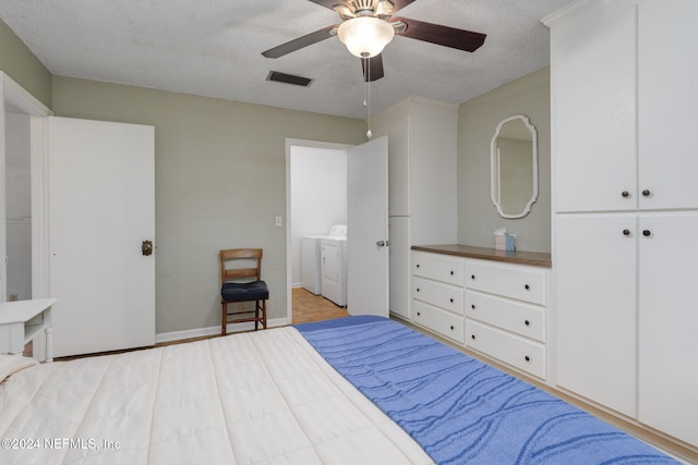 bedroom with a closet, ceiling fan, a textured ceiling, and washer and dryer