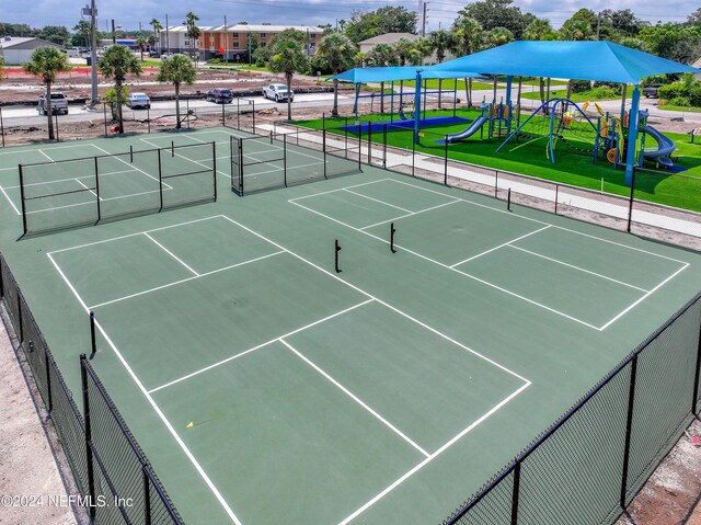 view of tennis court with a playground