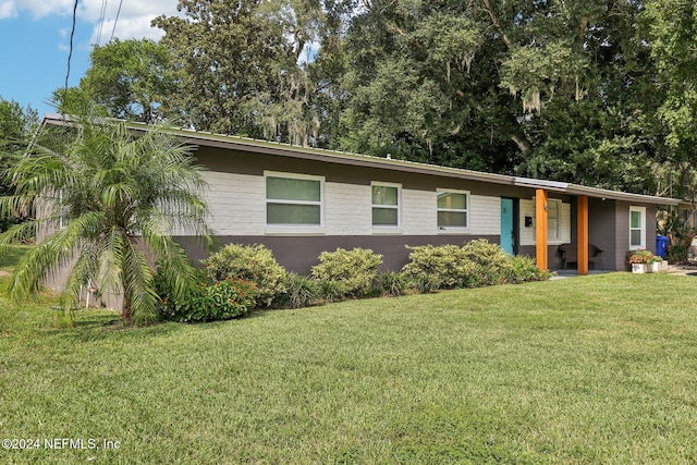 view of front facade featuring brick siding and a front lawn