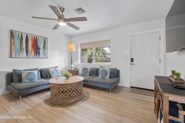 living room featuring a ceiling fan, visible vents, and wood tiled floor