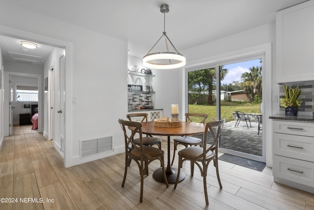 dining space featuring visible vents, baseboards, and wood tiled floor