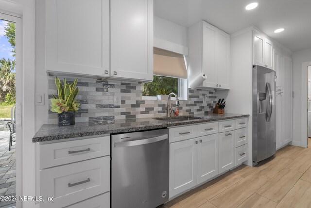 kitchen with white cabinets, plenty of natural light, and stainless steel appliances