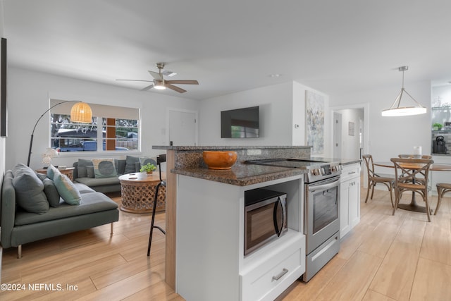 kitchen featuring appliances with stainless steel finishes, light hardwood / wood-style floors, ceiling fan, pendant lighting, and white cabinets