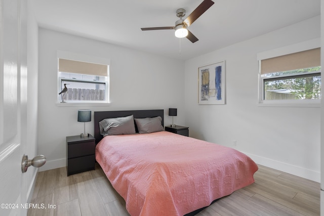 bedroom with a ceiling fan, baseboards, and light wood-type flooring