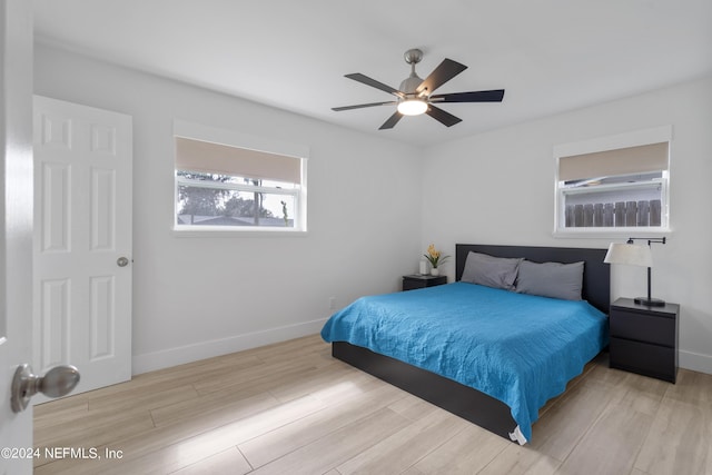 bedroom featuring ceiling fan, baseboards, and wood finished floors