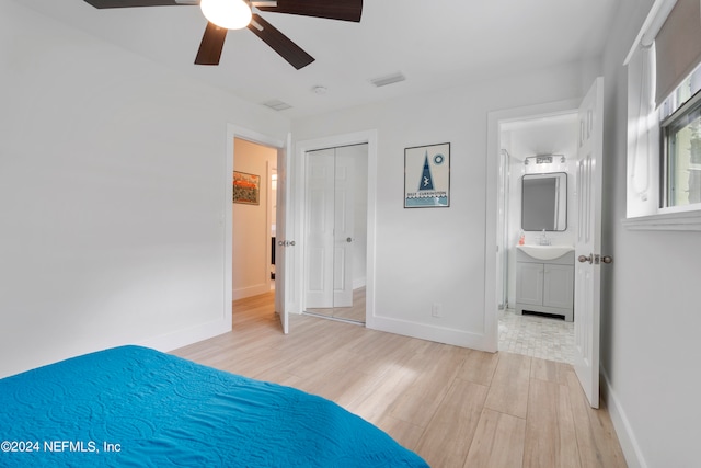 unfurnished bedroom with light hardwood / wood-style floors, sink, ensuite bath, a closet, and ceiling fan