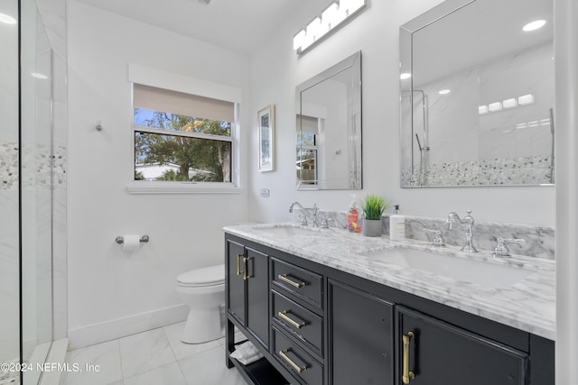 full bath featuring a sink, baseboards, toilet, and double vanity