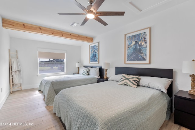 bedroom featuring ceiling fan, light hardwood / wood-style flooring, and beamed ceiling