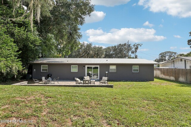 rear view of property featuring a patio area and a yard