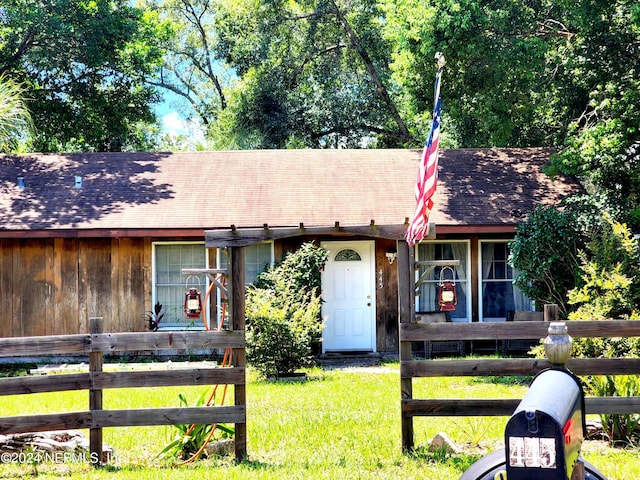 view of front of home with fence and a front lawn