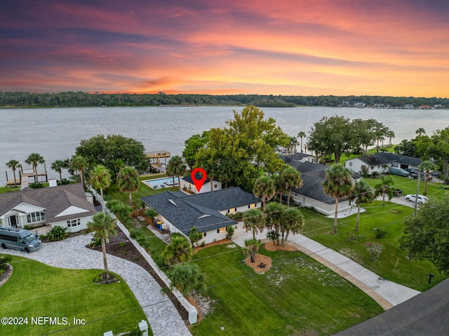 aerial view at dusk featuring a water view