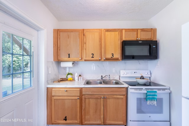 kitchen featuring backsplash, sink, electric range, and a textured ceiling