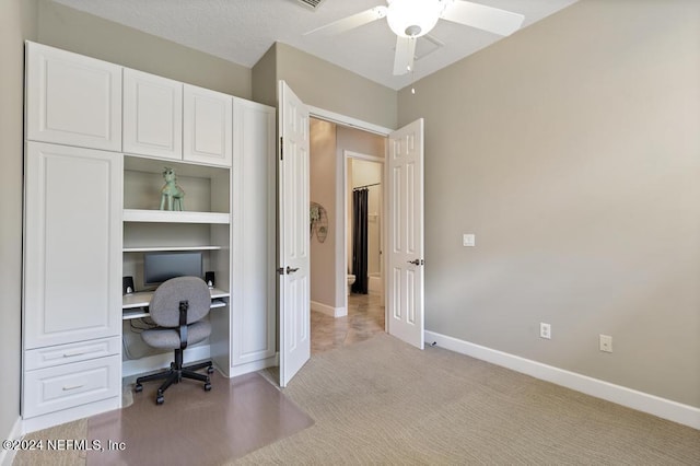 office area featuring a ceiling fan, baseboards, and light carpet