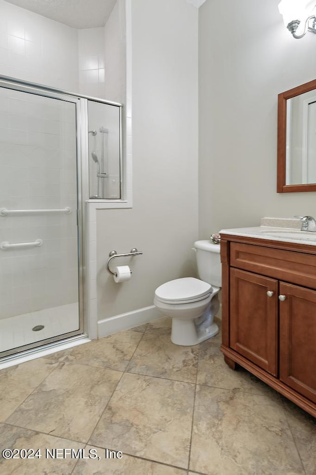 full bathroom featuring vanity, toilet, baseboards, and a stall shower