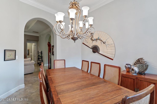 dining room with visible vents, baseboards, ornamental molding, arched walkways, and a notable chandelier