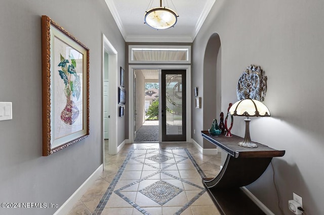 foyer entrance with arched walkways, crown molding, and baseboards