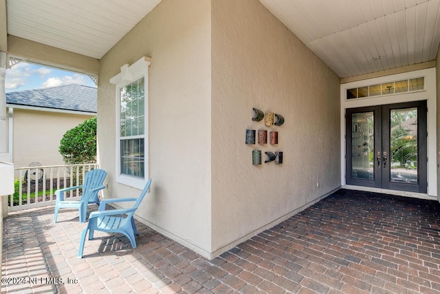 property entrance featuring stucco siding and french doors