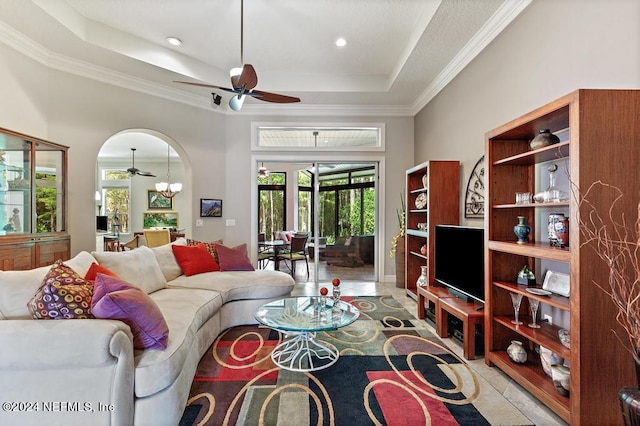 living area with a raised ceiling, ornamental molding, a ceiling fan, and tile patterned flooring