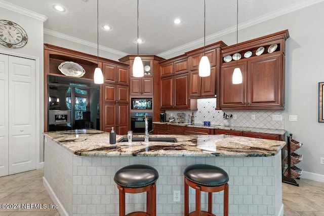 kitchen with light stone countertops, a breakfast bar, ornamental molding, decorative backsplash, and black appliances