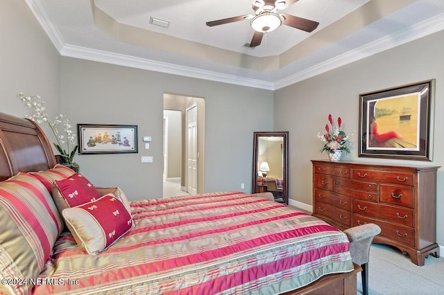 bedroom with visible vents, ornamental molding, a ceiling fan, a raised ceiling, and light colored carpet