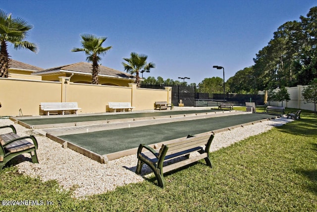 view of community featuring a lawn and fence