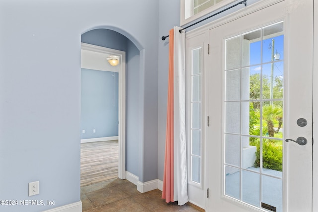 entrance foyer featuring a wealth of natural light, arched walkways, and baseboards