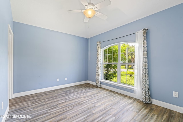 empty room with ceiling fan, baseboards, and wood finished floors