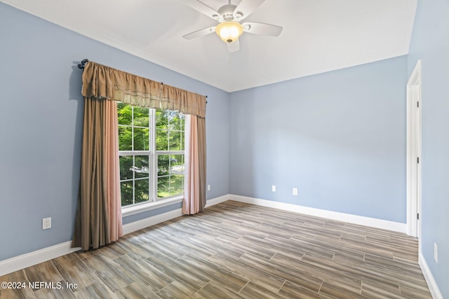 unfurnished room with a ceiling fan, baseboards, and wood finished floors