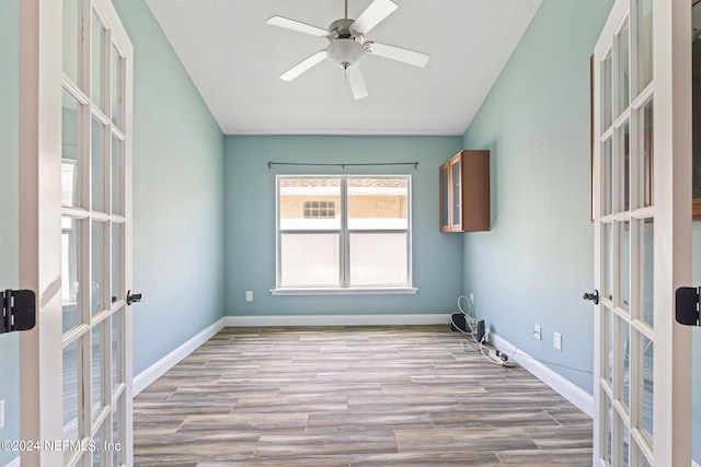 spare room with french doors, light hardwood / wood-style flooring, and ceiling fan