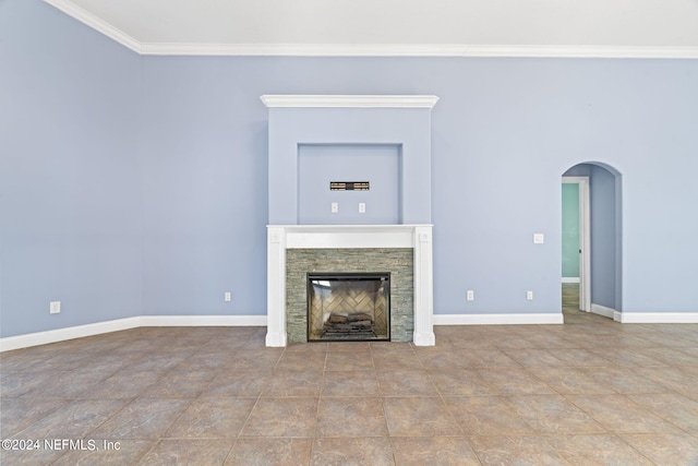 unfurnished living room with arched walkways, ornamental molding, a fireplace, and baseboards