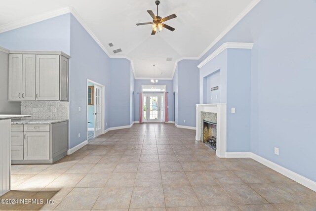 unfurnished living room featuring ornamental molding, ceiling fan, and light tile patterned flooring