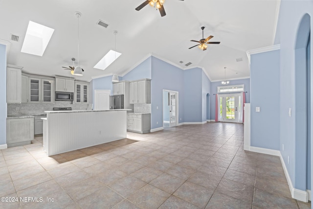 kitchen featuring crown molding, visible vents, appliances with stainless steel finishes, lofted ceiling with skylight, and ceiling fan