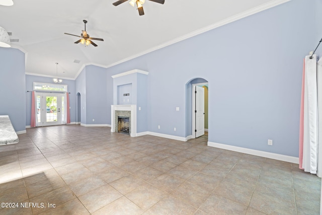 unfurnished living room featuring ornamental molding, arched walkways, baseboards, and ceiling fan with notable chandelier